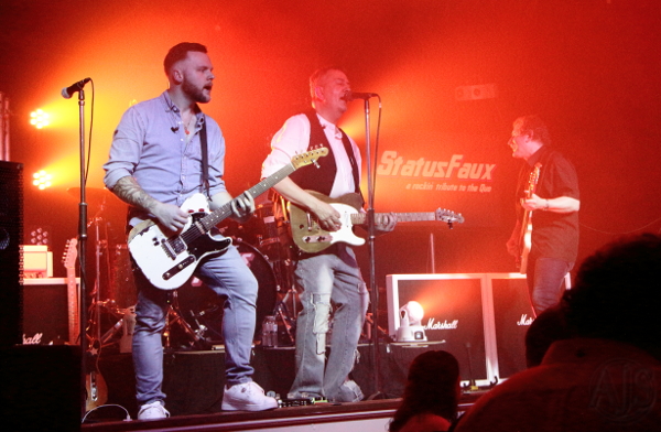 The band on an orange lit stage.