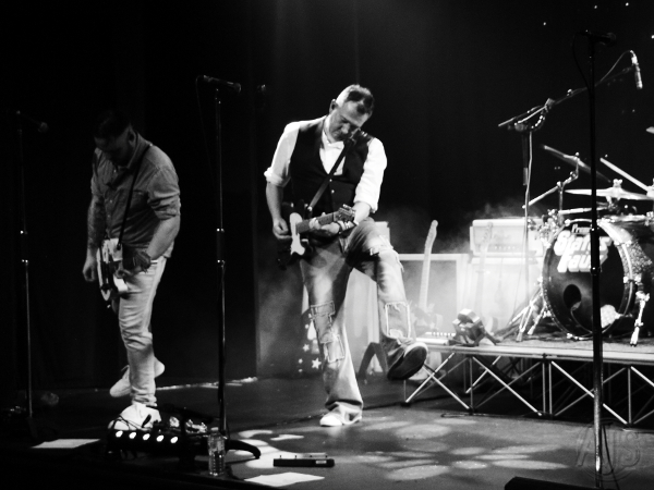 The two Status Faux guitarists on stage performing.